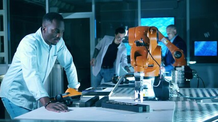 Wall Mural - african ethnicity researcher is operating a robot with an electronic device.