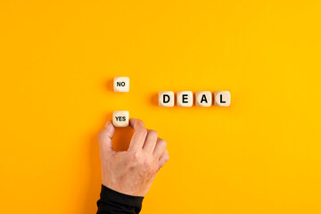 Wall Mural - The word deal on wooden blocks with a male hand choosing the yes option. To accept a business deal