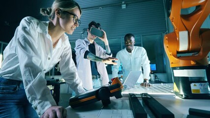 Wall Mural - researchers are operating a robotic arm in virtual reality. professional engineers working at modern