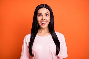 Wall Mural - Portrait of shocked young lady open mouth smile look camera cant believe isolated on orange color background