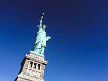 Low Angle Shot Of The Statue Of Liberty Under A Blue Sky In New York