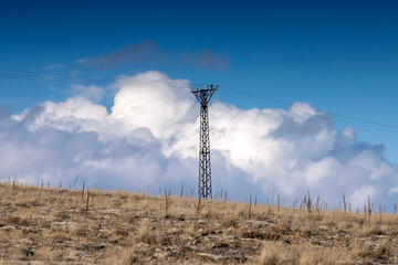 High voltage electric pole and transmission lines. High voltage grid tower with wire cable at distribution station.