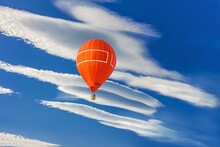 Orange Balloon Amid Blue Sky . Soar In The Clouds