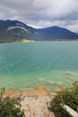 Sticker - Vertical shot of the mesmerizing shot of a sea surrounded by mountains under the cloudy sky