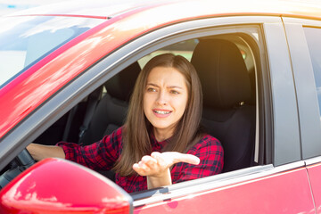 Wall Mural - Young smiling woman in casual dress driving modern car