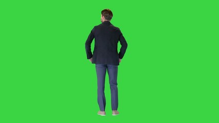 confident businessman standing with hands on hips looking around on a green screen, chroma key.