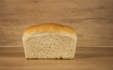 Fresh out of the oven loaf of homemade whole wheat bread on a wooden table