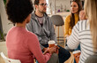 © Zoran Zeremski - Diverse group of people sitting in circle in group therapy session.