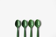 4 Green Plastic Spoons On White Background. Zero Waste Concept