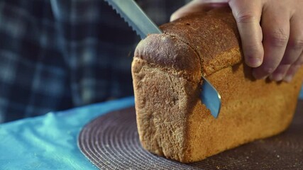 Wall Mural - Male hands cutting homemade bread. Fresh bread on the table close-up. Healthy food, baking concept