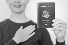 A New American Citizen Holding A USA Passport And Pledging Oath At The American Embassy Office. Emigration And Citizenship.
