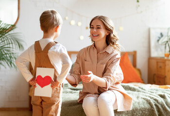 Wall Mural - boy making surprise for mother during holiday celebration