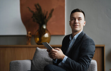 social network chat with partners. The economist is a man in a business suit sitting in a modern office. the consultant prints a text message on the tablet.