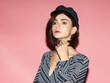 © Sergey Chumakov - close up portrait of fashion brunette woman in vintage cap isolated on pink background