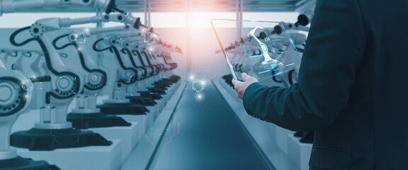 Wall Mural - industry engineer in factory,using smart tablet glass device,control automated robot arm machine lea