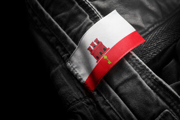 Tag on dark clothing in the form of the flag of the Gibraltar