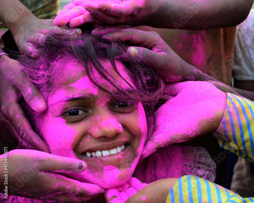 Cropped Hands Of Applying Pink Powder Paint On Happy Female Friend During Holi