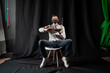 © Alexander - Man in a medical mask uses a laptop on a dark background
