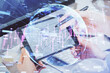 © peshkova - Double exposure of man's hands holding and using a phone and financial chart drawing. Market analysis concept.