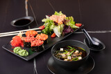 Fototapeta  - Japanese food, sushi, rolls, soup, salad on black background
