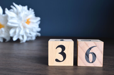 Wall Mural - Number 36, rating, award, Empty cover design in natural concept with a number cube and peony flower on wooden table for a background.