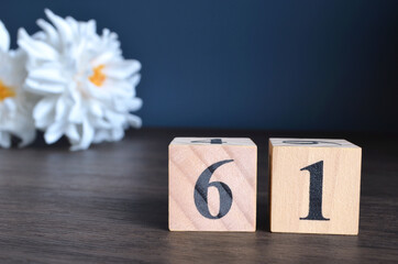 Wall Mural - Number 61, rating, award, Empty cover design in natural concept with a number cube and peony flower on wooden table for a background.