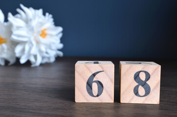 Wall Mural - Number 68, rating, award, Empty cover design in natural concept with a number cube and peony flower on wooden table for a background.