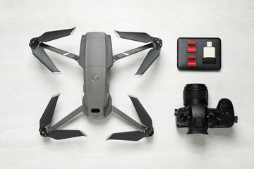 Wall Mural - modern drone, camera and video production equipment on white table, flat lay