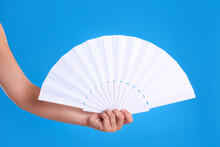 Woman Holding White Hand Fan On Light Blue Background, Closeup