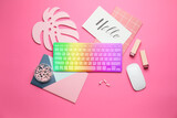 Fototapeta Kwiaty - Colorful computer keyboard with stationery and lipsticks on pink background