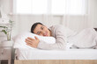 © Pixel-Shot - Morning of young man lying on bed with soft mattress