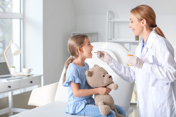 Sticker - Pediatrician giving medicine to little girl in clinic