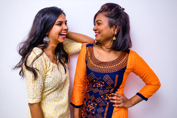 casual indian clothes ,two Indian woman in kurta posing over white wall