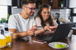 © lordn - Happy couple using credit card for online shopping at home