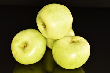 Several natural green apples by Renet Simirenko, close-up, isolated on black.