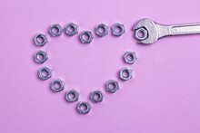The Heart Of The Nuts With A Wrench On A Purple Paper Background.
