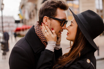 Wall Mural - Romantic couple face to face hugging and smiling. Warm cozy colors, winter mood.