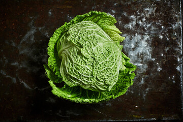 Cut fresh savoy cabbages on black table, flat lay. Space for text