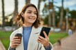 © Krakenimages.com - Young hispanic woman using smartphone and drinking coffee at the city.