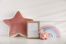 Empty Photo Frame, Cute Toy Unicorn And Pillow Near Wall, Space For Text. Baby Room Interior Element