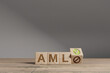 Wood cubes with acronym ''AML' - 'Anti Money Laundering' on a beautiful wooden table, studio background. Business concept and copy space.