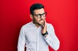 © Krakenimages.com - Young hispanic businessman wearing shirt and glasses touching mouth with hand with painful expression because of toothache or dental illness on teeth. dentist