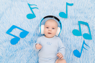 Wall Mural - baby listening to music with headphones on a blue mat