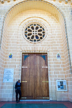 Tourist With Cap Posing Next To A Door Of A Church In Malta