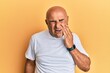 © Krakenimages.com - Mature middle east man wearing casual white tshirt touching mouth with hand with painful expression because of toothache or dental illness on teeth. dentist