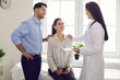 © Studio Romantic - Happy married couple seeing family doctor. Clinician talking to young husband and wife. Patients listening to gynecologist at health center or hospital. Effective treatment, planning pregnancy concept