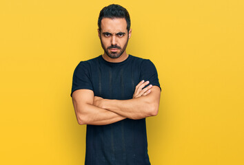 Young hispanic man wearing casual clothes skeptic and nervous, disapproving expression on face with crossed arms. negative person.