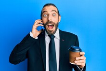 Attractive Business Man With Long Hair And Beard Using Smartphone And Drinking A Cup Of Coffee Celebrating Crazy And Amazed For Success With Open Eyes Screaming Excited.
