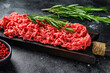 Fresh Raw mince beef, ground meat with herbs and spices. Black background. Top view