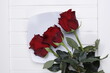 róże trzy duże czerwone na białym blacie
